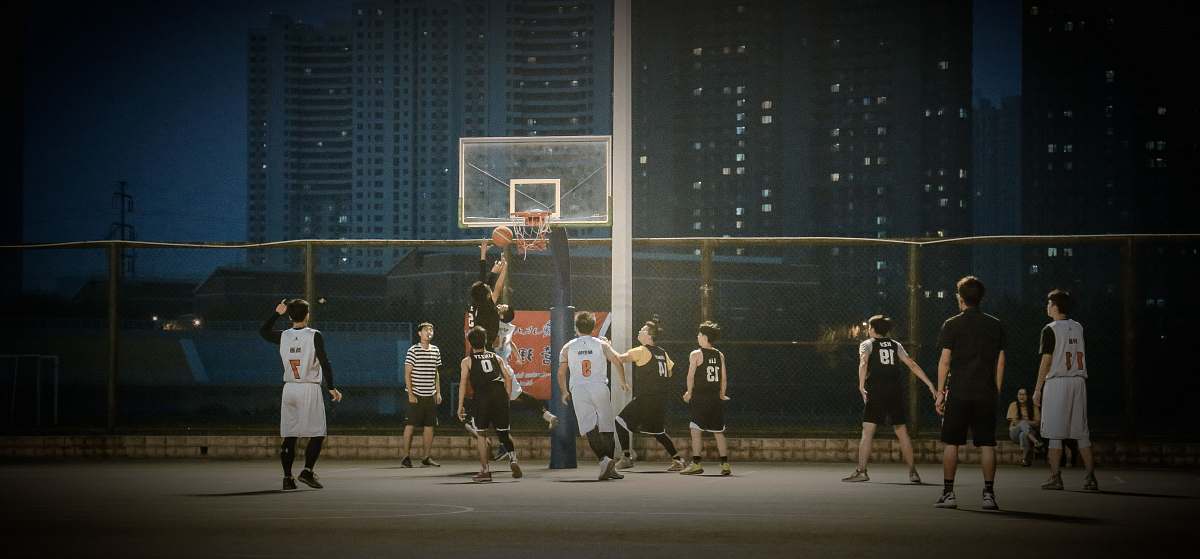 human group of men playing basketball during nighttime music